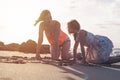 Mother and daughter having fun drawing with sand at sunset on tropical beach - Happy mom playing with her kid in vacation Royalty Free Stock Photo