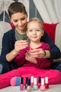 Mother and daughter having fun painting fingernails