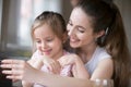 Mother and daughter having fun playing smartphone together Royalty Free Stock Photo