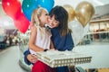 Mother and daughter having fun in shopping mall toghether