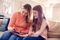 Mother And Daughter Having Fun Sitting On Sofa At Home Doing Nails Together Royalty Free Stock Photo