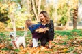 Mother and daughter having fun together outdoors. Fashionable mother and schoolgirl walking with their dog in park Royalty Free Stock Photo