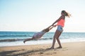 Mother and daughter having fun on tropical beach - Mum playing with her kid in holiday vacation next to the ocean - Family Royalty Free Stock Photo