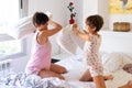 Mother and daughter having funny pillow fight on bed. Royalty Free Stock Photo