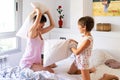 Mother and daughter having funny pillow fight on bed. Royalty Free Stock Photo