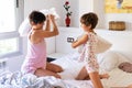 Mother and daughter having funny pillow fight on bed. Royalty Free Stock Photo