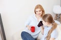 Mother and daughter having tea on sofa Royalty Free Stock Photo