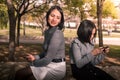 Mother and daughter having time together on the park using the smartphone to play and chat. Addicted little girl Royalty Free Stock Photo