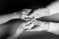 Mother and daughter holding hands. Close-up. Flat lay. Black and white colors. The concept of caring for pensioners