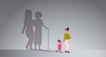 Mother with daughter holding hands shadow of young and mature woman standing together imagination aspiration concept