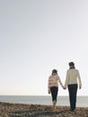 Mother And daughter Holding Hands And Walking On Beach