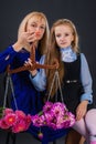 Mother and daughter are holding scales, on the bowls of which are flowers. Royalty Free Stock Photo