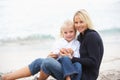 Mother And Daughter On Holiday Sitting On Beach Royalty Free Stock Photo