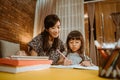 Mother and daughter home schooling studying together