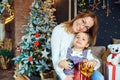 Mother and daughter hugging by the Christmas tree. Royalty Free Stock Photo