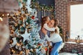 Mother and daughter hugging by the Christmas tree. Royalty Free Stock Photo