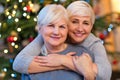 Mother and daughter hugging by Christmas tree Royalty Free Stock Photo