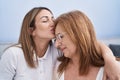 Mother and daughter hugging each other and kissing sitting on sofa at home Royalty Free Stock Photo