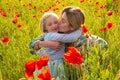 Mother and daughter hugging on flowering poppy field. Summer family holidays on nature. Summer on poppies meadow with Royalty Free Stock Photo