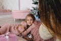 Mother and daughter hugging near Christmas tree. woman and girl with a Christmas present Royalty Free Stock Photo