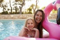 Mother And Daughter On Inflatables In Outdoor Swimming Pool Royalty Free Stock Photo