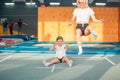 Mother and daughter jumping on trampoline and doing split Royalty Free Stock Photo