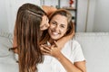 Mother and daughter kissing and hugging each other sitting on sofa at home Royalty Free Stock Photo