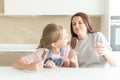 Mother with daughter in kitchen eating ice cream. Good relations of parent and child. Happy family concept Royalty Free Stock Photo