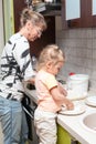 Mother and daughter kneading the dough together in kitchen