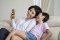 Mother and daughter laughing together on the couch Royalty Free Stock Photo