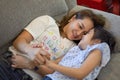 Mother and daughter laying on sofa and talking together. Happy loving family.  child girl  playing and hugging Mom on bed in Royalty Free Stock Photo