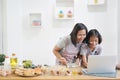 Mother and daughter learn cooking using laptop computer in the kitchen