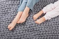 Mother and daughter legs on woolen knitted plaid