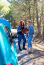 two women checking documents with broken down car Royalty Free Stock Photo