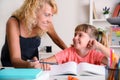 Mother and daughter looking with complicity in school studies home