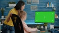 Mother and daughter looking at horizontal green screen on computer Royalty Free Stock Photo