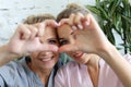 Mother and daughter love. Adult woman and young woman stacking hands in heart sign looking at camera. Royalty Free Stock Photo