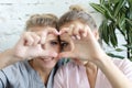 Mother and daughter love. Adult woman and young woman stacking hands in heart sign looking at camera. Royalty Free Stock Photo