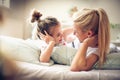 Mother and daughter lying on a bed looking etch other.