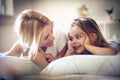 Mother and daughter lying on a bed, morning time.