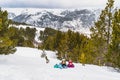 Mother and daughter lying down on a snow smiling and looking at camera. Winter ski holidays, Andorra Royalty Free Stock Photo