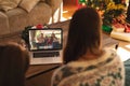 Mother and daughter making christmas laptop video call with happy caucasian family waving