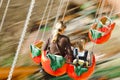 Mother with daughter moving fast on carousel. Motion blur captured, focused on bodies Royalty Free Stock Photo