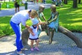 Mother with daughter near metallic sculpture of children and turtle in city park Royalty Free Stock Photo