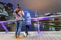 Mother and daughter at night photographing city skyline from beautiful modern bridge Royalty Free Stock Photo