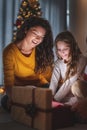Mother and daughter opening Christmas presents