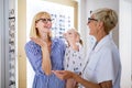 Mother and daughter in optician shop buying eyeglasses Royalty Free Stock Photo