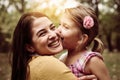 Mother and daughter outdoors in a meadow. Little girl kissing he Royalty Free Stock Photo