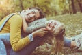 Mother and daughter outdoors in a meadow. Little girl lying on m Royalty Free Stock Photo