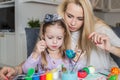 Mother And Daughter Painting Easter Eggs In Home